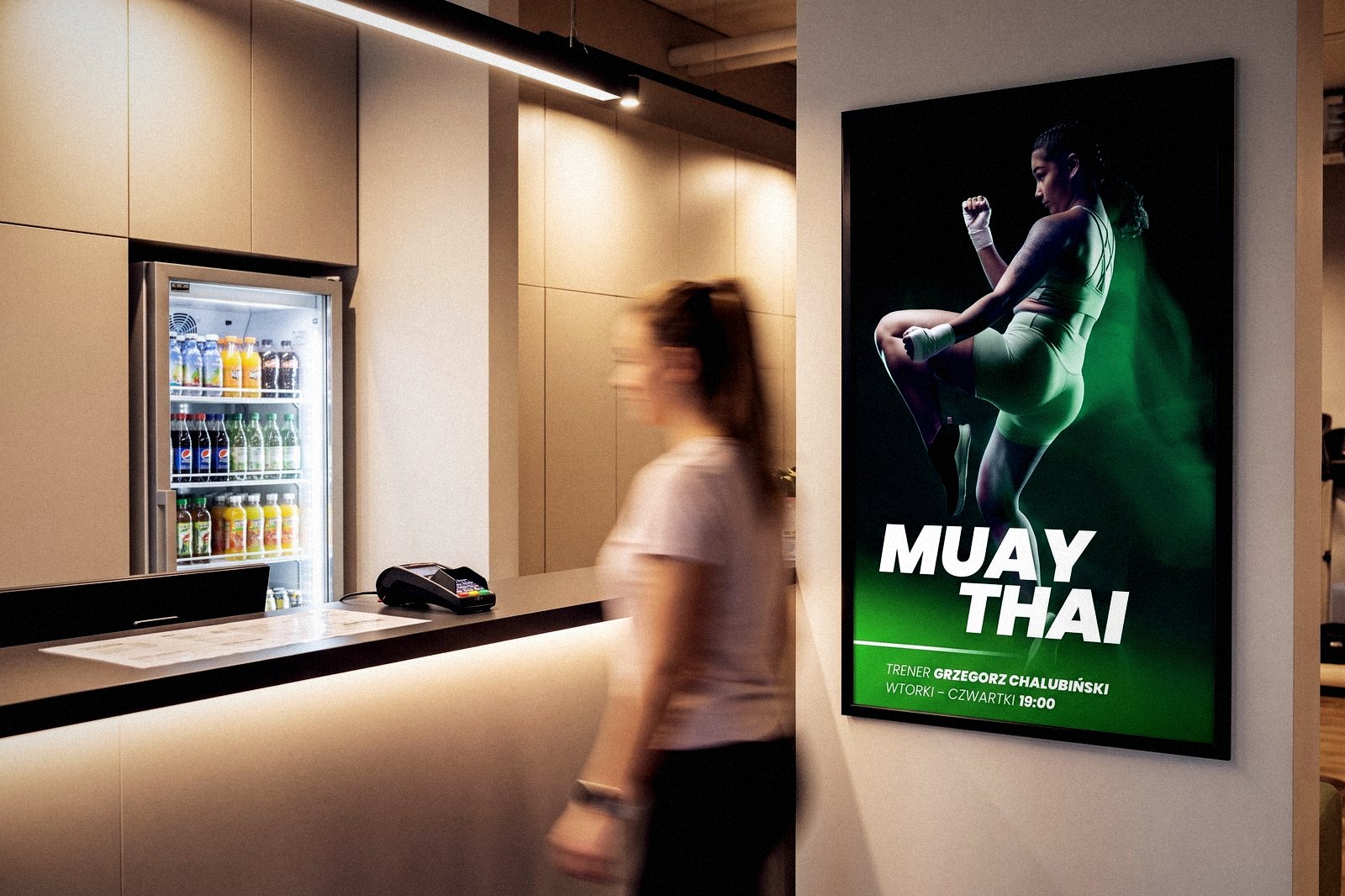 Plakat zajęć w ramie przy recepcji klubu